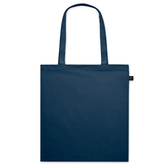Bolsa de tela azul oscuro OSOLE COLOUR con etiqueta de comercio justo y asas largas. Ideal para ferias, tiendas y campañas ecológicas.