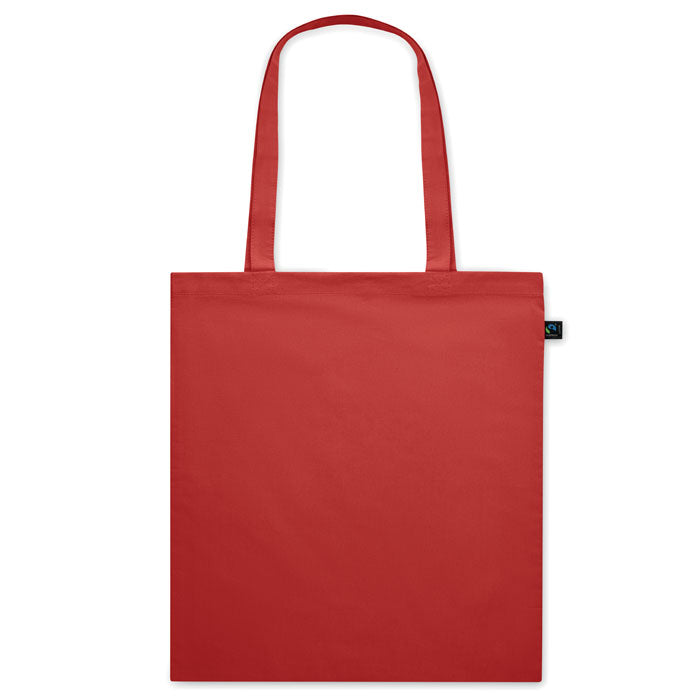 Bolsa ecológica OSOLE COLOUR roja con asas largas y etiqueta de comercio justo. Ideal como bolsa de tela para eventos o regalos promocionales.