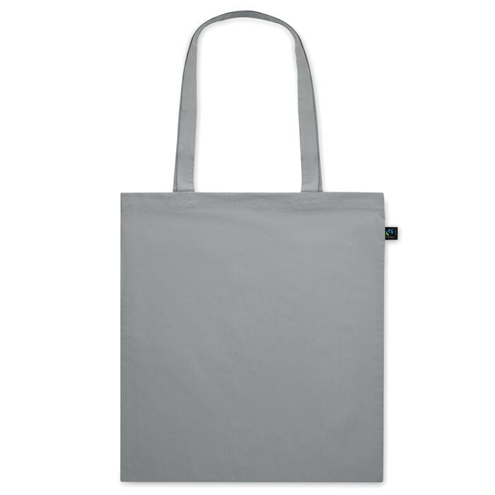 Bolsa de tela gris claro OSOLE COLOUR con asas largas y etiqueta de comercio justo. Ideal para ferias, tiendas y regalos ecológicos.