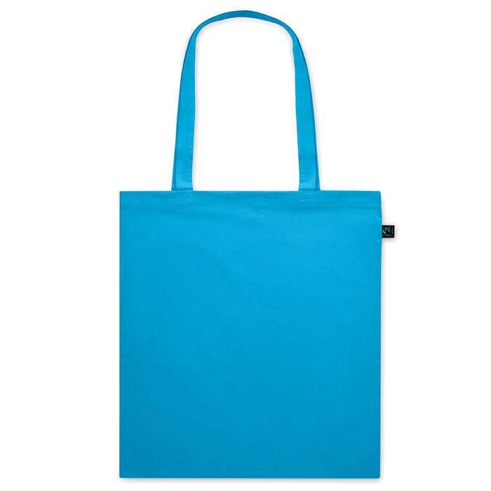 Bolsa de tela azul OSOLE COLOUR con etiqueta de comercio justo y asas largas. Ideal para ferias, tiendas ecológicas y regalos corporativos.