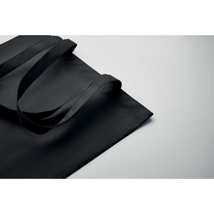 Detalle de la bolsa KAIMANI negra RPET 80 gr/m² con asas largas, mostrando su acabado resistente y ecológico para uso diario.