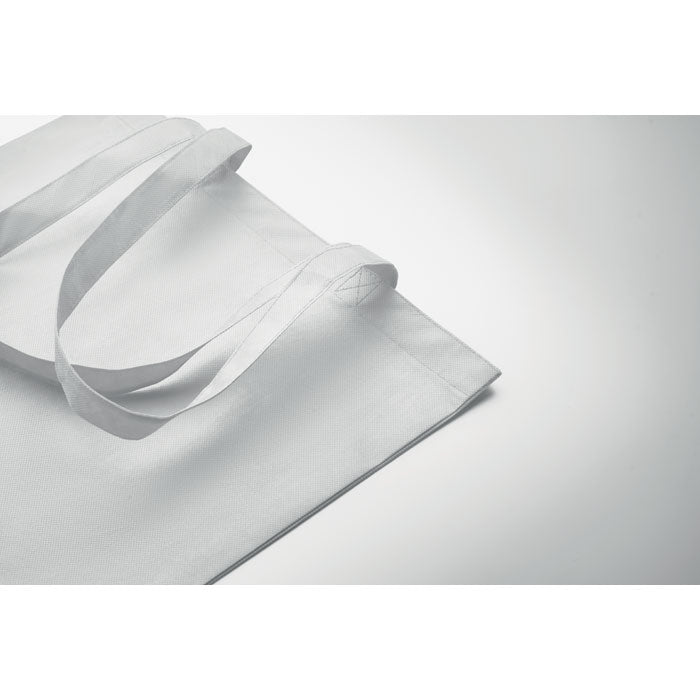 Detalle de la bolsa KAIMANI blanca RPET 80 gr/m² con asas largas, mostrando su textura suave y ecológica para uso promocional.