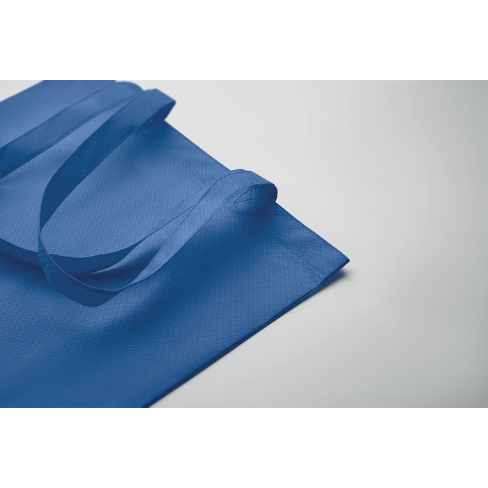 Detalle de la bolsa KAIMANI azul royal RPET 80 gr/m², mostrando su diseño resistente y ecológico para uso diario o promocional.