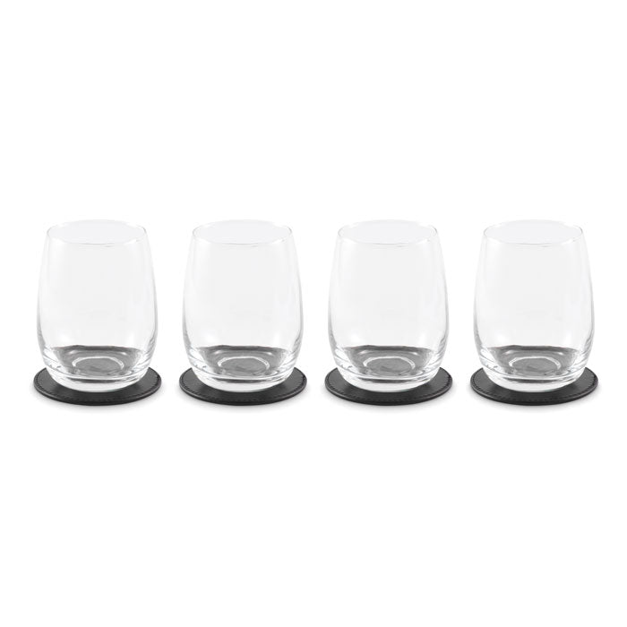 Cuatro vasos de cristal elegantes sobre posavasos de PU negro, ideales para cualquier mesa.