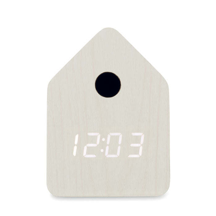 Vista frontal de un reloj despertador de MDF en forma de casa con pantalla LED que muestra la hora 12:03.