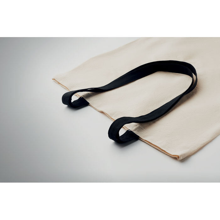 Detalle de las asas largas negras de la bolsa ZEVRA de algodón 140 gr/m². Diseño resistente y cómodo para llevar en el hombro.