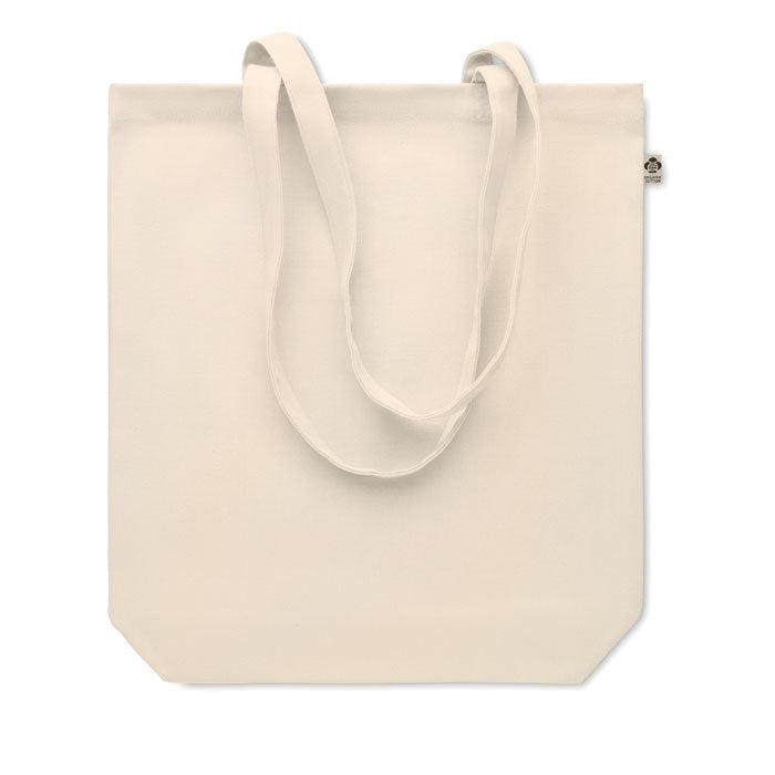 Bolsa de canvas orgánico de color beige con asas largas y fuelle inferior, vista frontal.