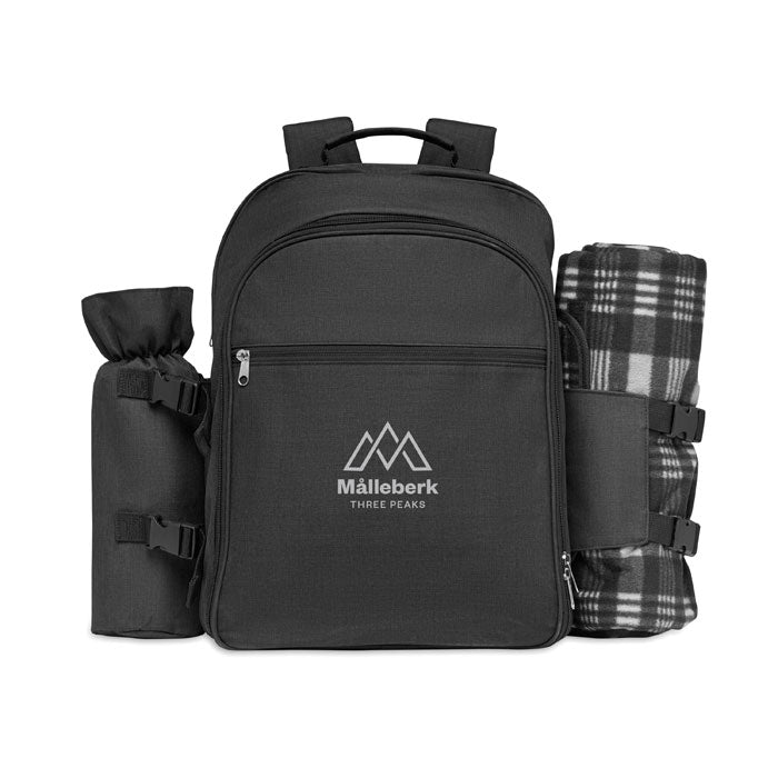 Mochila negra de poliéster con manta a cuadros y compartimento lateral, ideal para picnic. Diseño funcional y elegante.