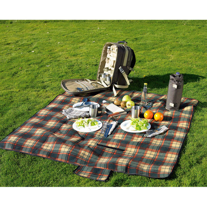 Foto de cesped con manta de picnic de cuadros, comida, platos y mochila