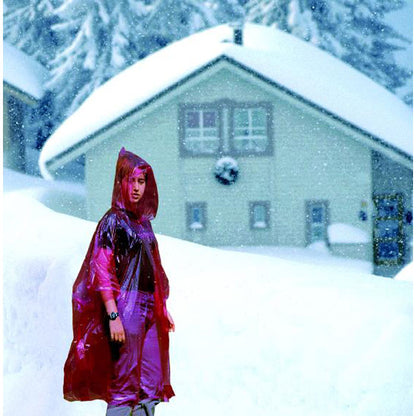 Mujer con impermeable rojo translúcido en paisaje nevado