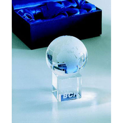 Pisapapeles de cristal en forma de globo terráqueo en mesa y con caja azul de presentación 