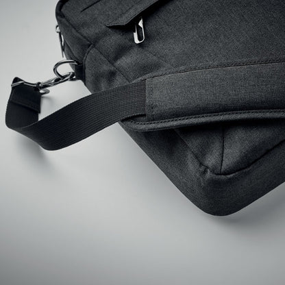 Mochila negra de poliéster reciclado con gran capacidad y bolsillo pequeño frontal, diseñada para un transporte cómodo y seguro.