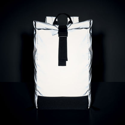 Efecto reflectante de mochila iluminada sobre fondo oscuro