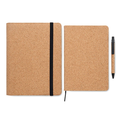 Libreta A5 abierta con hojas rayadas y cinta marcapáginas de tela negra y bolígrafo de corcho con pulsador, punta y clip de plástico negro