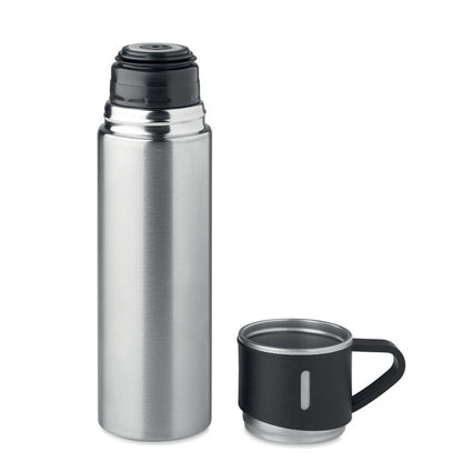 Botella de acero plata con taza de tapa al lado