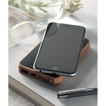 Móvil negro sobre power bank de acacia