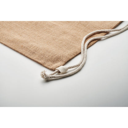Detalle de cordones blancos de algodón para cerrar mochila de yute