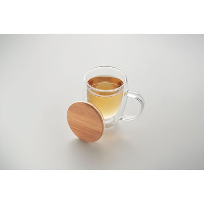vista superior de infusión en taza de cristal de doble pared con tapa de bambú