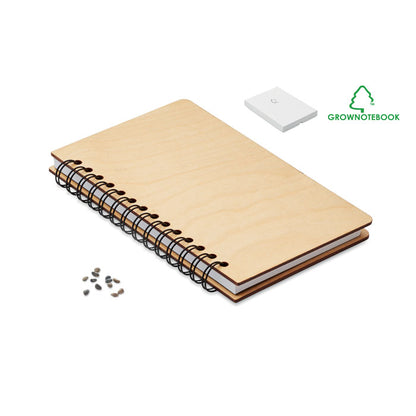 Cuaderno con tapas de madera clara y espiral negra con semillas de abedul en caja blanca