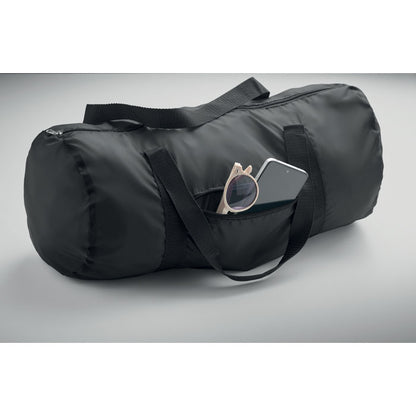 Bolsa negra de poliéster con bolsillo exterior con unas gafas de sol y un teléfono móvil dentro