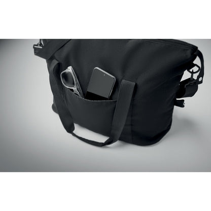 Detalle de bolsillo exterior de bolsa de fin de semana larga con teléfono móvil y gafas de sol en el interior