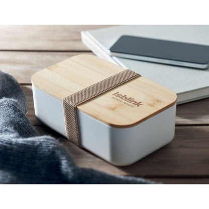 Fiambrera de color beige sobre una mesa de madera