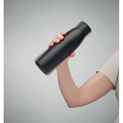 Mano sujetando botella negra metálica