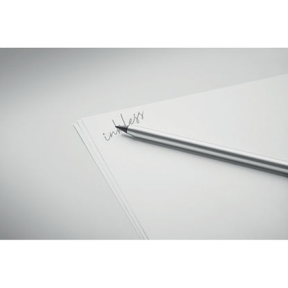 Bolígrafo de aluminio gris sobre hoja de papel donde está escrita la palabra inkless