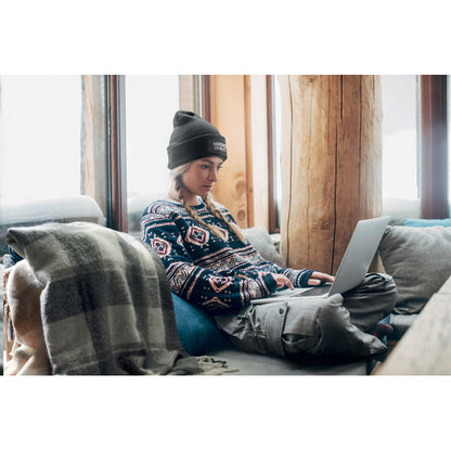 Mujer en sofá con gorro de punto negro