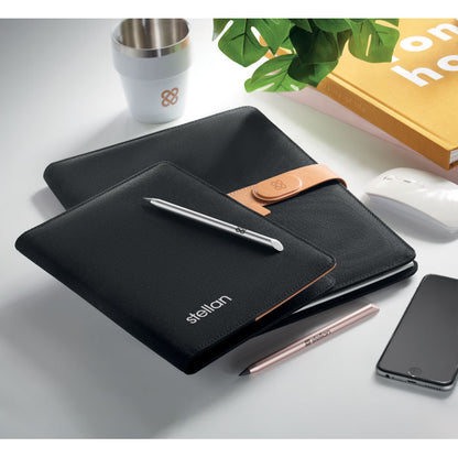 Portadocumentos negro con  cierre de polipel marrón magnético sobre mesa de oficina