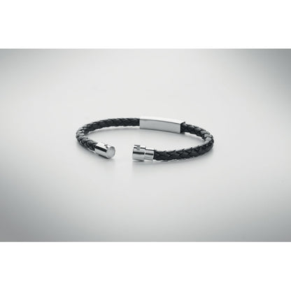 brazalete de piel y acero abierto sobre fondo gris