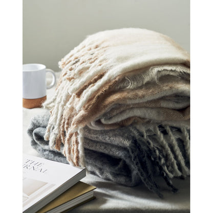 Mantas de RPET mohair en mesa con taza y libros