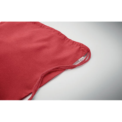 Detalle de cordones de cierre de mochila de algodón roja y etiqueta Recycled cosida