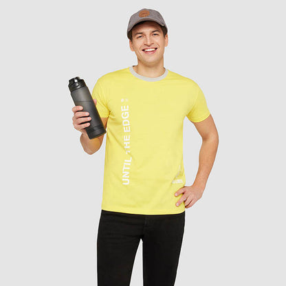 Hombre con camiseta amarilla y botella deportiva negra