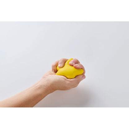 Mano utilizando un anti estres amarillo en forma de estrella