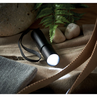 Linterna LED negra resistente y recargable para uso exterior.