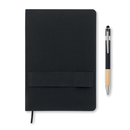 Portada de libreta A5 color negro con banda elástica en la portada junto a bolígrafo de aluminio negro con parte inferior de madera de bambú 