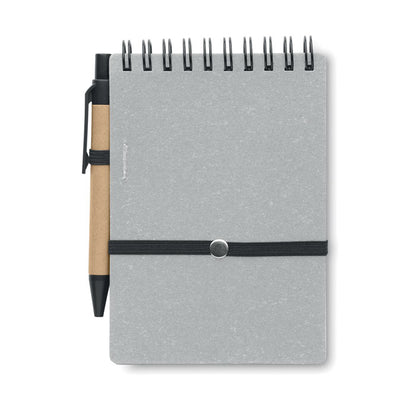 Contraportada de libreta de cartón gris con espiral negra en la parte superior y cierre de goma negra y con bolígrafo de cartón y detalles negros en la parte izquierda