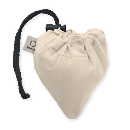 Bolsa de algodón coloe natural plegada sobre sí misma con mosquetón de cierre de plástico negro