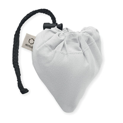 bolsa blanca de algodón plegada sobre sí misma con etiqueta  Recycled y cerrada con mosquetón 