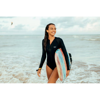 Mujer surfera en la playa con tabla de surf con pulsera amarilla