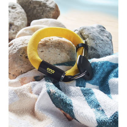 Rocas de playa con toalla y pulsera flotante amarilla con logo impreso