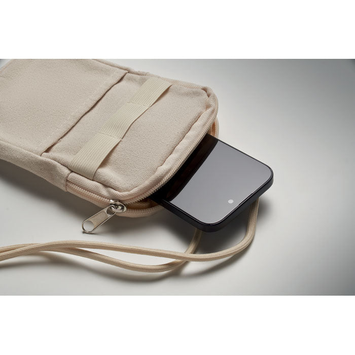Vista cercana de un bolso bandolera para smartphone con un teléfono asomando, elaborado en algodón reciclado.