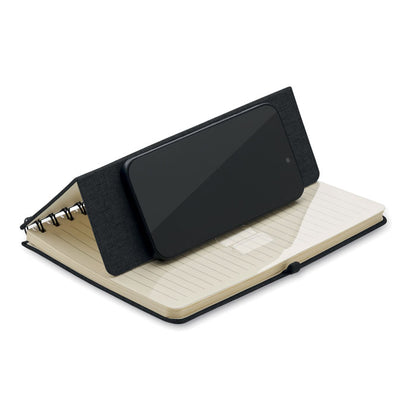 Teléfono móvil en horizontal sobre soporte en libreta con espiral