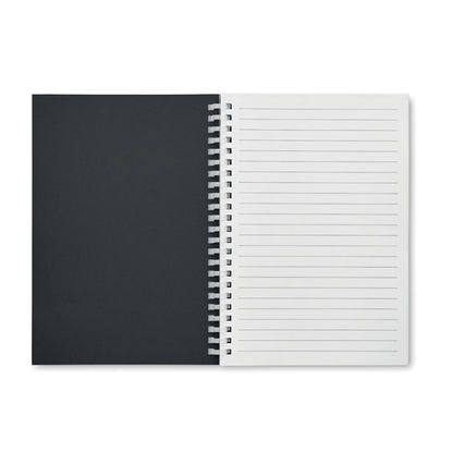 Libreta A5 abierta por la primera hoja con vista de interior de portada de cartón negro y hoja rayada blanca