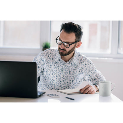 Hombre con gafas trabajando con portátil y libreta