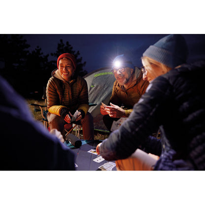 Grupo de amigos jugando a las cartas por la noche en un ambiente de montaña