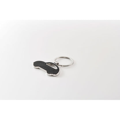 Llavero con forma de coche de metal y PU negro sobre un fondo neutro gris