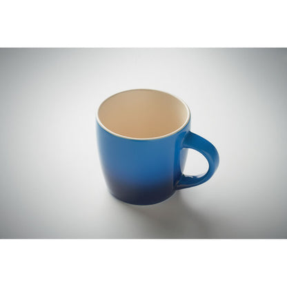 Taza de cerámica blanca en el interior y tonos degradados azules en el exterior