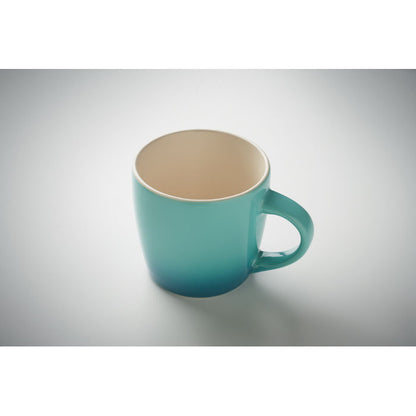 Taza de cerámica blanca en el interior y tonos degradados turquesas en el exterior